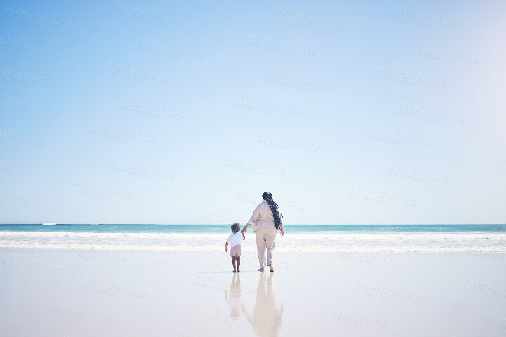 Buy stock photo Mother, son and beach with back, space and mock up with blue sky, lens flare and bonding with love in summer. Mama, male kid and holding hands for care, vacation and sea mockup with waves in sunshine