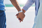 Unity, love and couple holding hands at a beach with trust, solidarity and commitment in nature. Hand, care and man with woman on romantic walk at the sea, sweet and bonding while traveling together