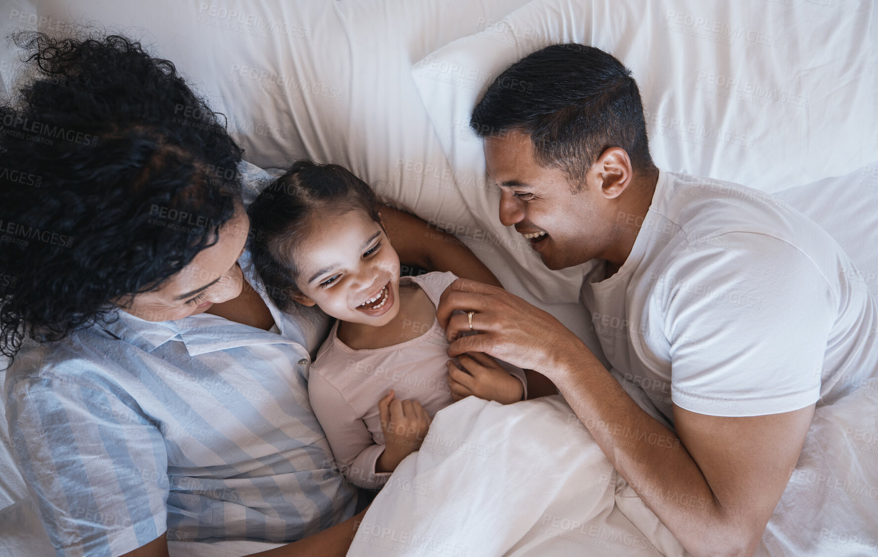 Buy stock photo Mom, dad and child laugh in a bedroom bed in the morning at family home with bonding. Tickle, mother and father with a young girl being playful and happy with a smile and youth together with love