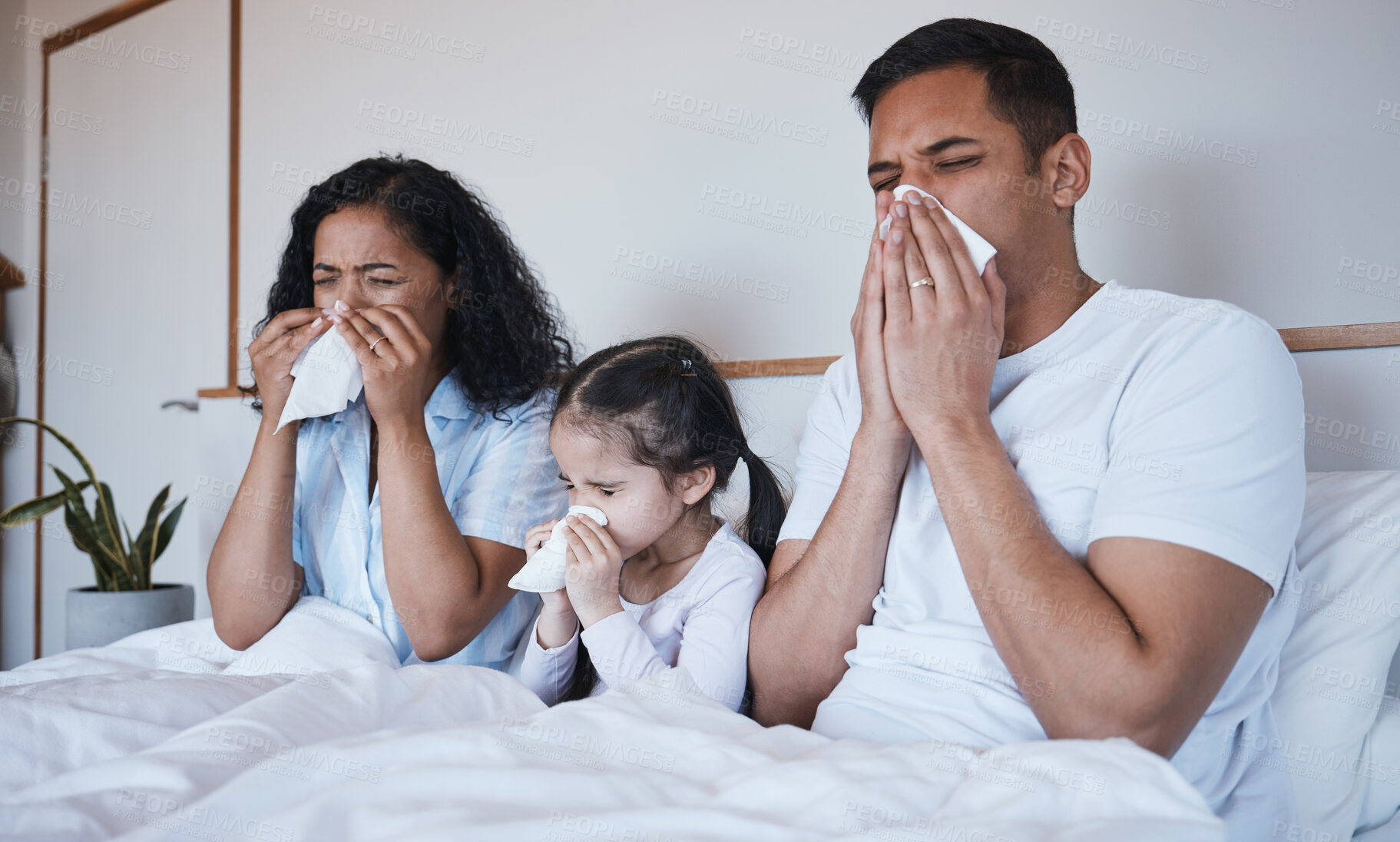 Buy stock photo Sick, family and blowing nose in bed in home lying in bedroom together in house. Flu, parents and child wipe with tissue with man, woman and girl with covid, virus or cold, disease or winter allergy