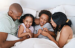 Happy family, relax and playing in bed above with smile in free time, weekend or fun holiday morning at home. Mother, father and children relaxing and laughing together for playful joy in the bedroom