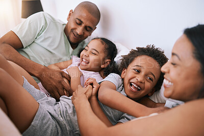 Buy stock photo Happy family, relax and playing in bed with smile for free time, weekend or fun holiday morning at home. Mother, father and children relaxing and laughing together for playful joy in the bedroom