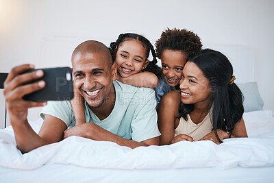 Buy stock photo Selfie, family and smile in home bedroom, bonding and relaxing or lying together. Bed, photo and children with mother and father taking pictures for happy memory, social media or profile picture.