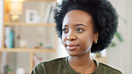 Face of a happy woman relaxing indoors on the weekend. Beautiful, cheerful and carefree African American girl having a stressless day at home relaxing in her modern bright living room apartment