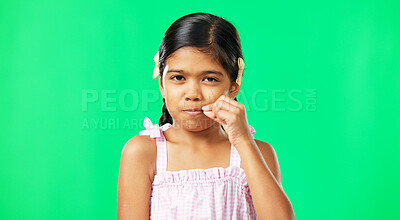 Children, secret and trust with a girl on a green screen background in studio zipping her lips. Portrait, kids and silent with an adorable little female child making a promise to keep quiet