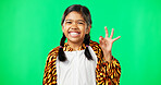 Children, perfect and hand gesture with a girl on a green screen background in studio feeling good. Portrait, smile and emoji with an adorable happy female child on chromakey mockup looking positive