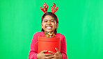 Christmas, gift box and happy with girl in green screen studio for youth, celebration and festive. Present, cheerful and vacation with portrait of child on background for season, holiday or happiness