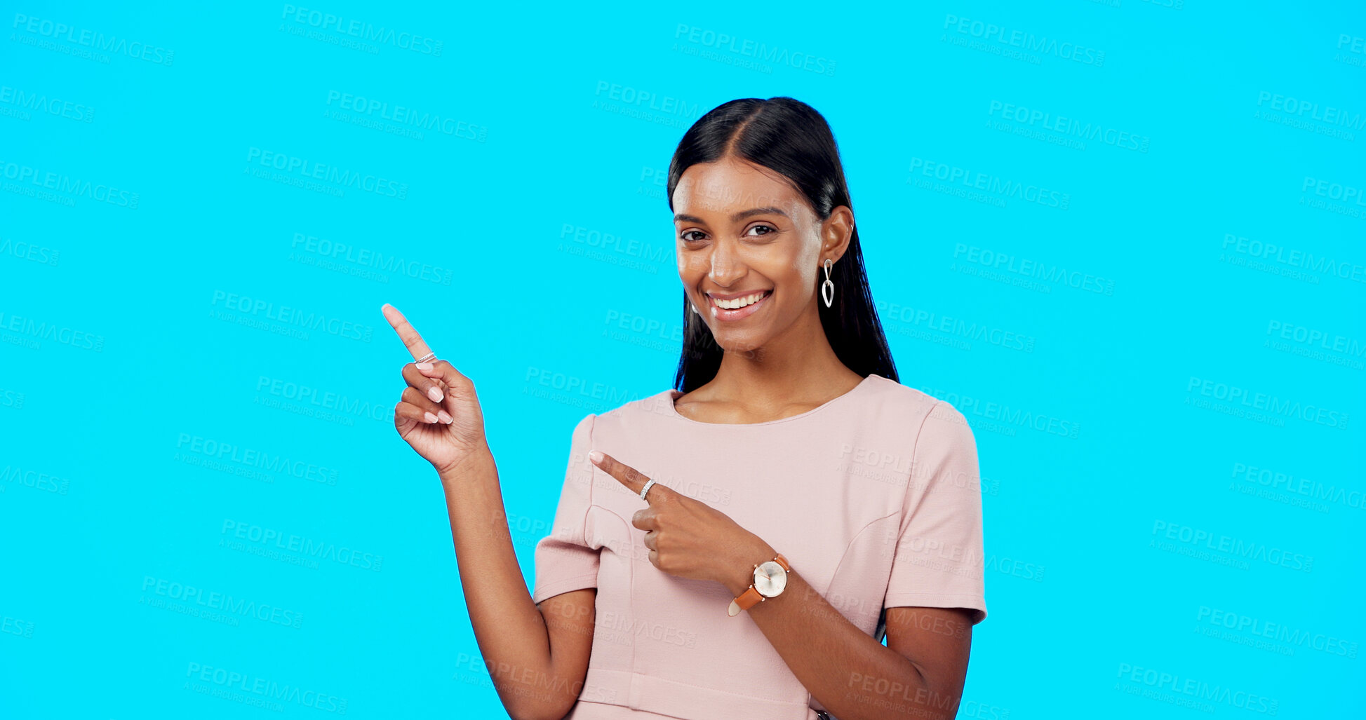 Buy stock photo Woman, portrait or advertising presentation in studio of information, promotion deal or choice on blue background. Happy indian model pointing to mockup space, announcement or launch of news about us