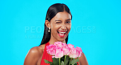 Flower bouquet, smile and beauty woman wink with nature gift, sustainable agriculture portrait or natural present. Funny flirty joke, floral studio roses and female person laugh on blue background