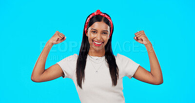 Buy stock photo Flexing, empowerment and woman showing arm muscle, strong and happy person isolated in a studio. Biceps, strength and portrait of excited Indian female model for body positivity by blue background.