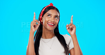 Face, motivation and Indian woman with decision, pointing and wellness against a blue studio background. Portrait, female and lady with smile, direction and choice with inspiration, promotion and joy
