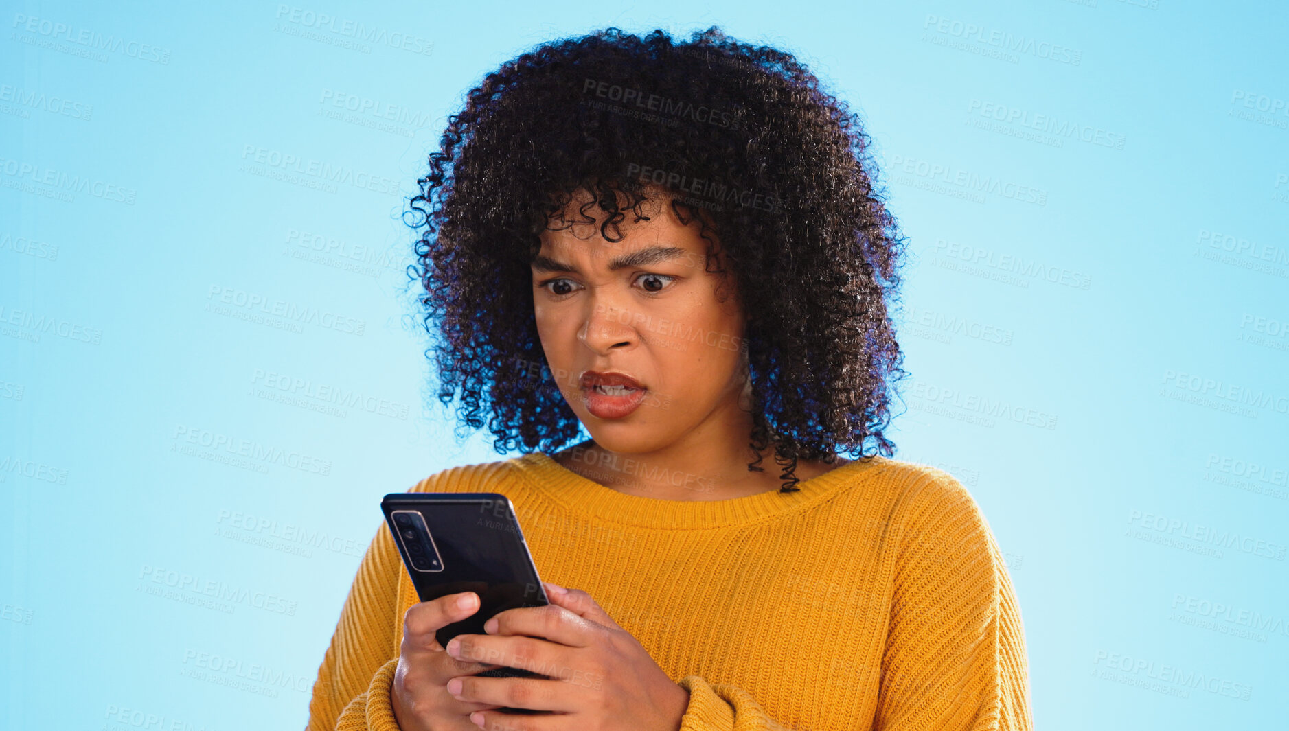 Buy stock photo Angry, smartphone and woman with scam, stress and bad news on social media isolated on a blue studio background. African person on phone, frustrated and reading spam, error and mobile glitch problem