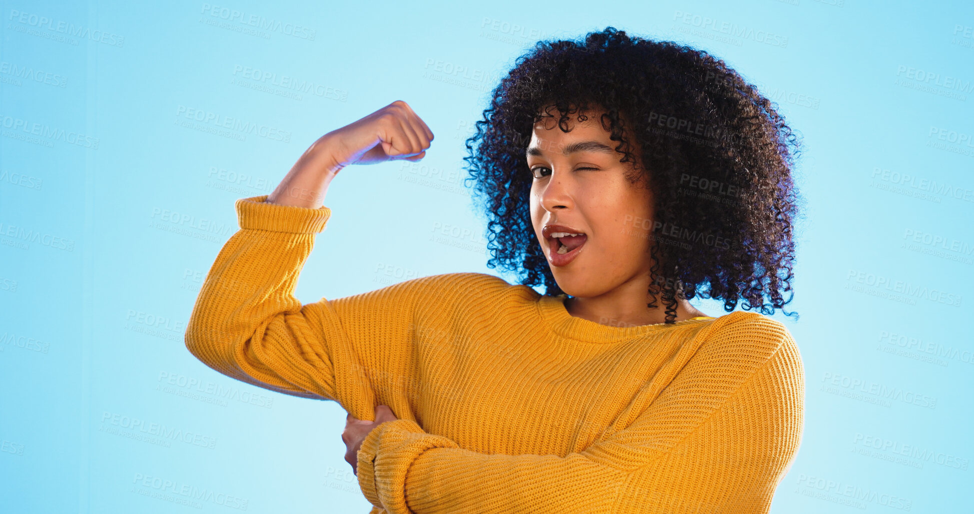 Buy stock photo Champion, woman flexing bicep and wink in portrait, muscle and strong with winner and playful isolated on blue background. Power, success and achievement with strength, flirt and confidence in studio