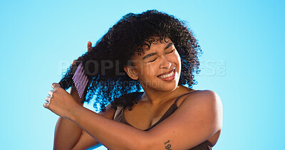 Frustrated, knot and black woman with comb for hair on blue background with problem, hairstyle frizz and damage. Beauty salon, hairdresser and sad girl brush afro for wellness, grooming and cosmetics
