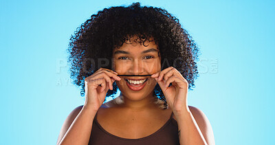 Buy stock photo Hair, moustache and portrait of a woman joking in studio on a blue background for fun or games. Happy, face or smile and a silly african female ,model playing with her hairstyle for comedy or funny