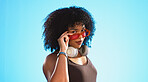 Face, sunglasses and beauty of woman in studio isolated on a blue background. Fashion portrait, smile shades and happy mixed race female model with trendy, stylish or retro, cool or gen z headphones.