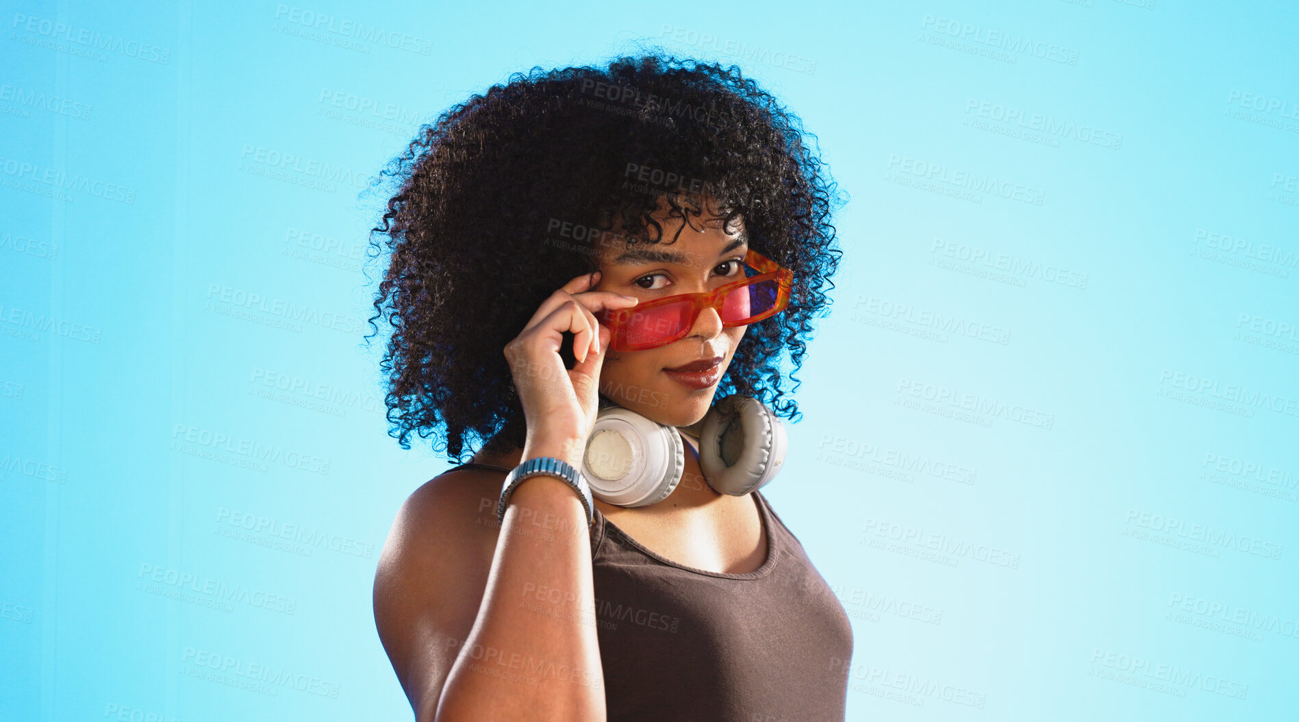 Buy stock photo Gen z, fashion and portrait of woman with sunglasses in studio on blue background with headphones. Beauty, face and gesture with vintage shades and confident model with trendy, cool or retro style