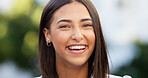 Portrait of a beautiful girl standing and commuting in the city. One happy and stylish young female smiling and relaxing downtown. Trendy young woman showing her teeth, laughing and traveling in town