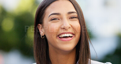 Portrait of a beautiful girl standing and commuting in the city. One happy and stylish young female smiling and relaxing downtown. Trendy young woman showing her teeth, laughing and traveling in town
