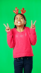 Girl child, peace sign and face by green screen studio in christmas mockup, reindeer costume or happiness. Emoji hands, kid and vertical portrait for holiday, festive cheer or happy childhood memory