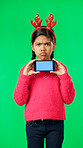 Christmas face, green screen and kid with phone in studio isolated on a background with tracking markers. Mockup, xmas and sad or unhappy girl with mobile smartphone for marketing or advertising.