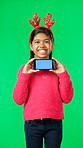 Christmas face, green screen and kid with phone in studio isolated on a background with tracking markers. Mockup, xmas and smile of happy girl with mobile smartphone for marketing or advertising.