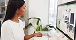 Fashion, design and computer with a woman designer writing creative notes in her notebook at work. Internet, technology and website with a young female employee working at her desk in a modern office