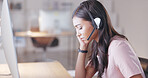 Young call center agent suffering from a headache or migraine while working in customer service. Support employee feeling tired, overworked and sick while wearing a headset at her desk in the office