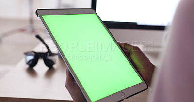 Close up of an African American person\'s hands holding a tablet with a plain green screen with a blurred background of headphones. Technician working out how to fix broken device. IT problem solving