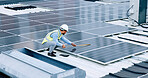 Engineer or contractor measuring solar panels on a roof of a building. Engineering technician or electrician installing alternative clean energy equipment and holding a tablet to record measurements