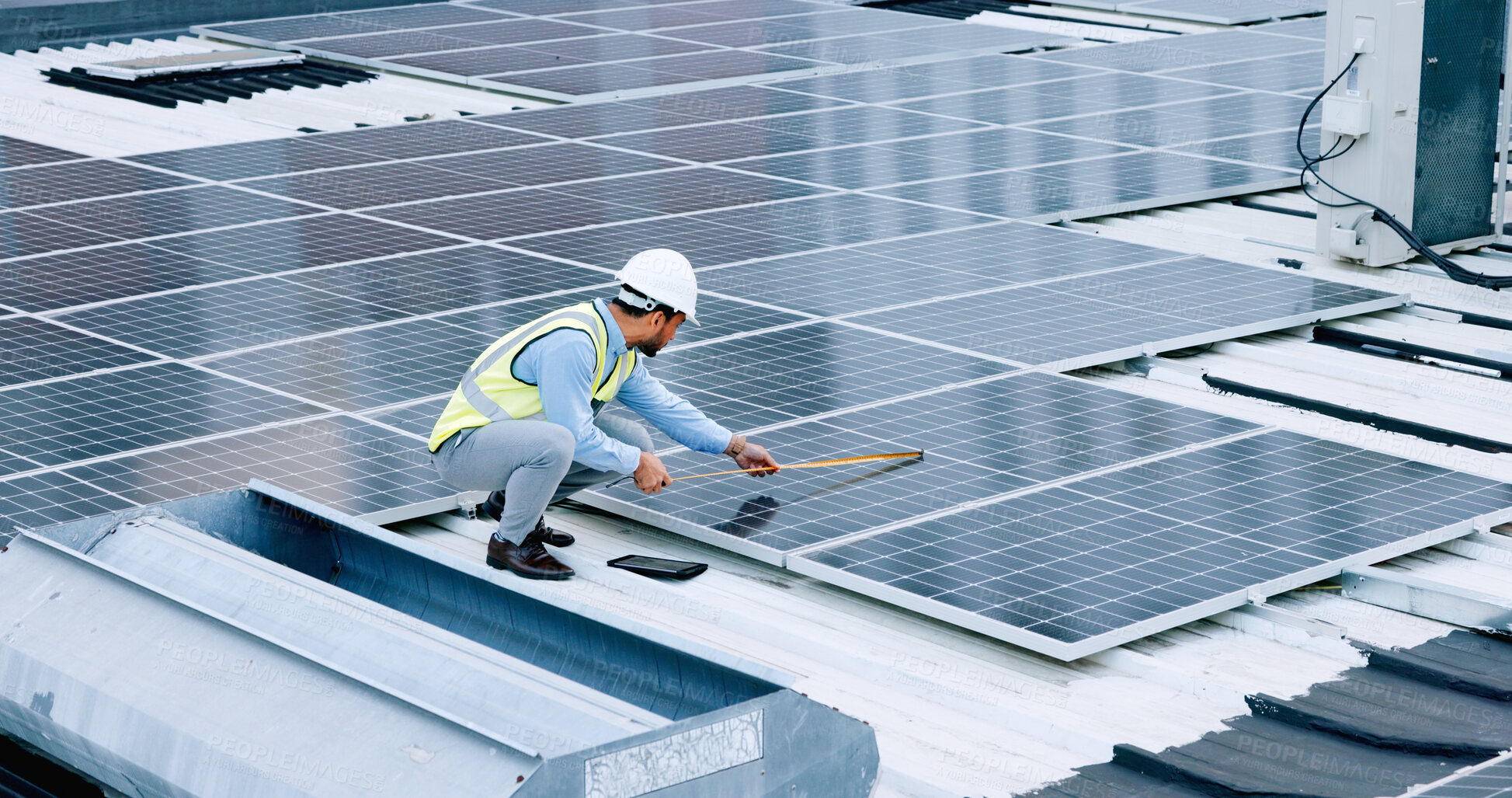 Buy stock photo Engineer, contractor measure and solar panel with man on roof with sustainability project. Engineering technician, green clean energy and eco friendly work with monitoring and maintenance from above