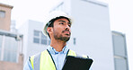 Construction worker holding a digital tablet while doing inspection. Organized male engineer or technician in a hardhat checking project plan with latest tech. Worker looking or overseeing operations