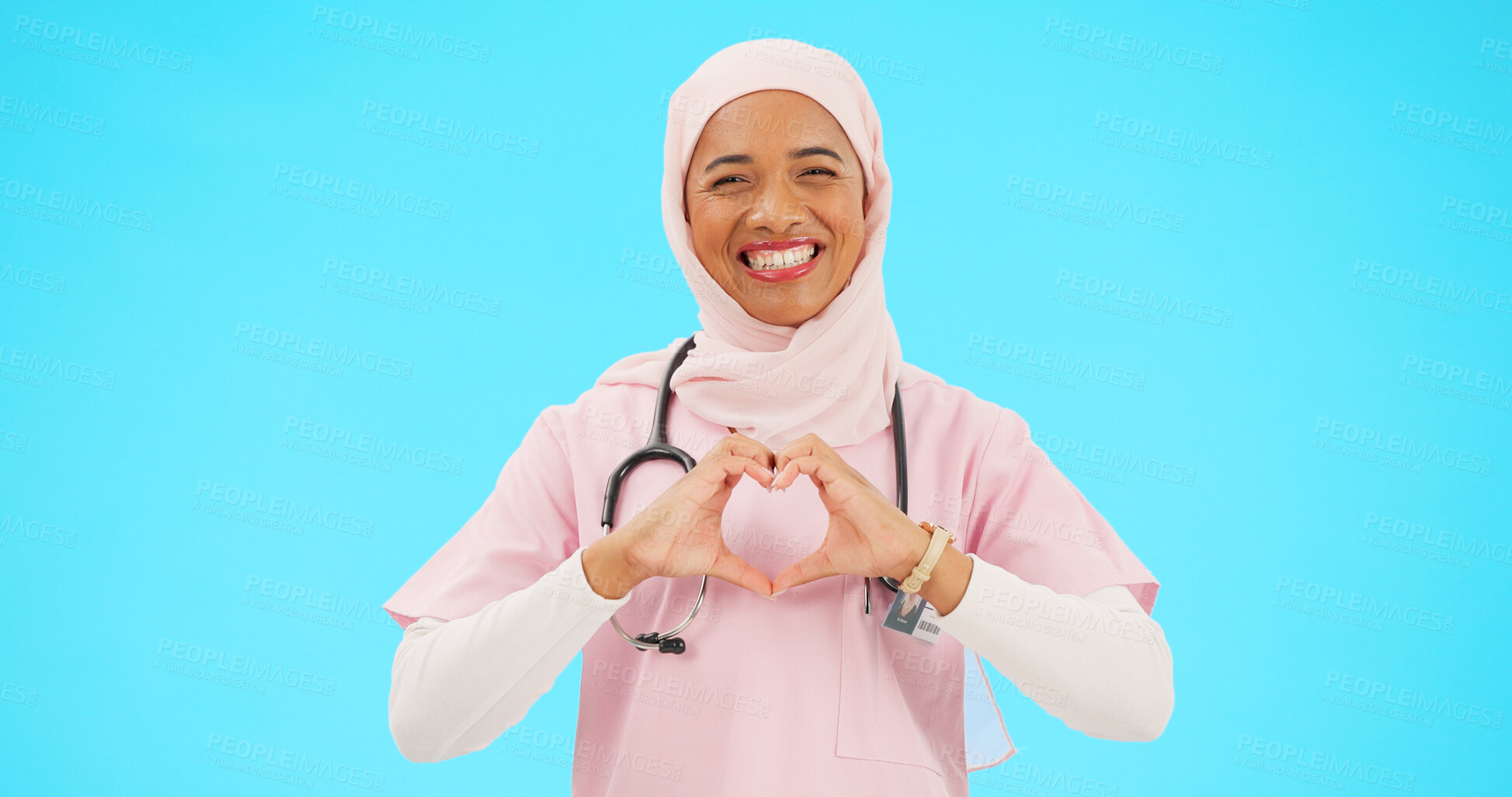 Buy stock photo Muslim woman, heart sign and doctor in studio portrait, review and good service by blue background. Islamic person, nurse and hijab with emoji, happy and cardiology for choice, feedback or healthcare