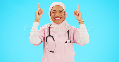 Buy stock photo Muslim nurse, portrait and pointing to healthcare information, offer or medical deal on studio background space. Doctor, professional and Islamic woman showing mockup, promotion and medicine choice