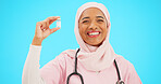 Nurse, healthcare and vaccine with a muslim woman on a blue background in studio for treatment. Medical, product and insurance with a young female medicine professional holding a glass bottle