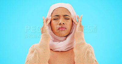 Buy stock photo Islamic woman, headache and stress in studio with hands, tired or massage for temple by blue background. Muslim person, migraine and hijab with pain, emergency or burnout with fatigue, fear or fail