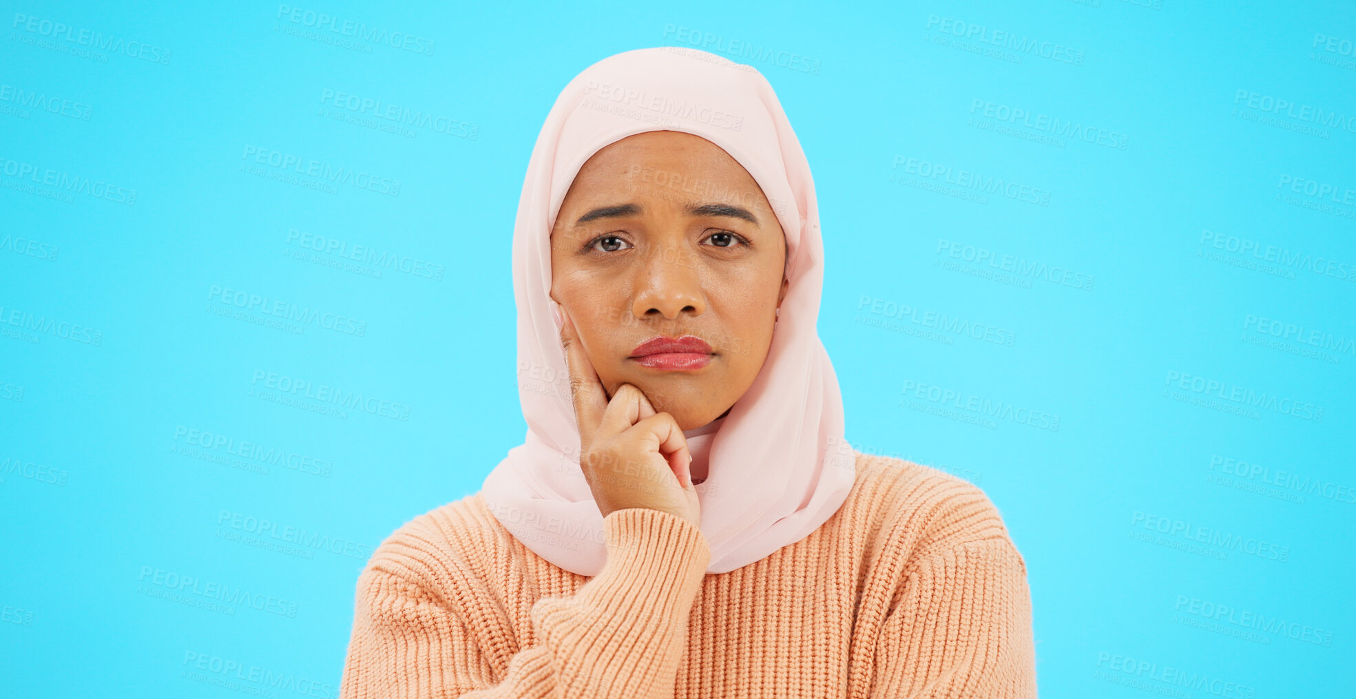 Buy stock photo Islamic woman, thinking and portrait with hand, face and mockup for advertising or thought. Confused, idea or hijab for doubt emoji, sad and think about option, choice and on a studio blue background