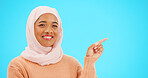 Muslim woman, happy and portrait pointing finger at space for mockup, advertising or promotion. Islam female with hand, smile and hijab for product placement announcement or sale on blue background