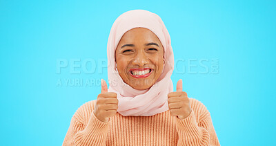 Buy stock photo Muslim woman, portrait and thumbs up with hijab in winning, success or studio against a blue background. Happy female person in Islam smile with scarf, like emoji or yes sign for good job on mockup