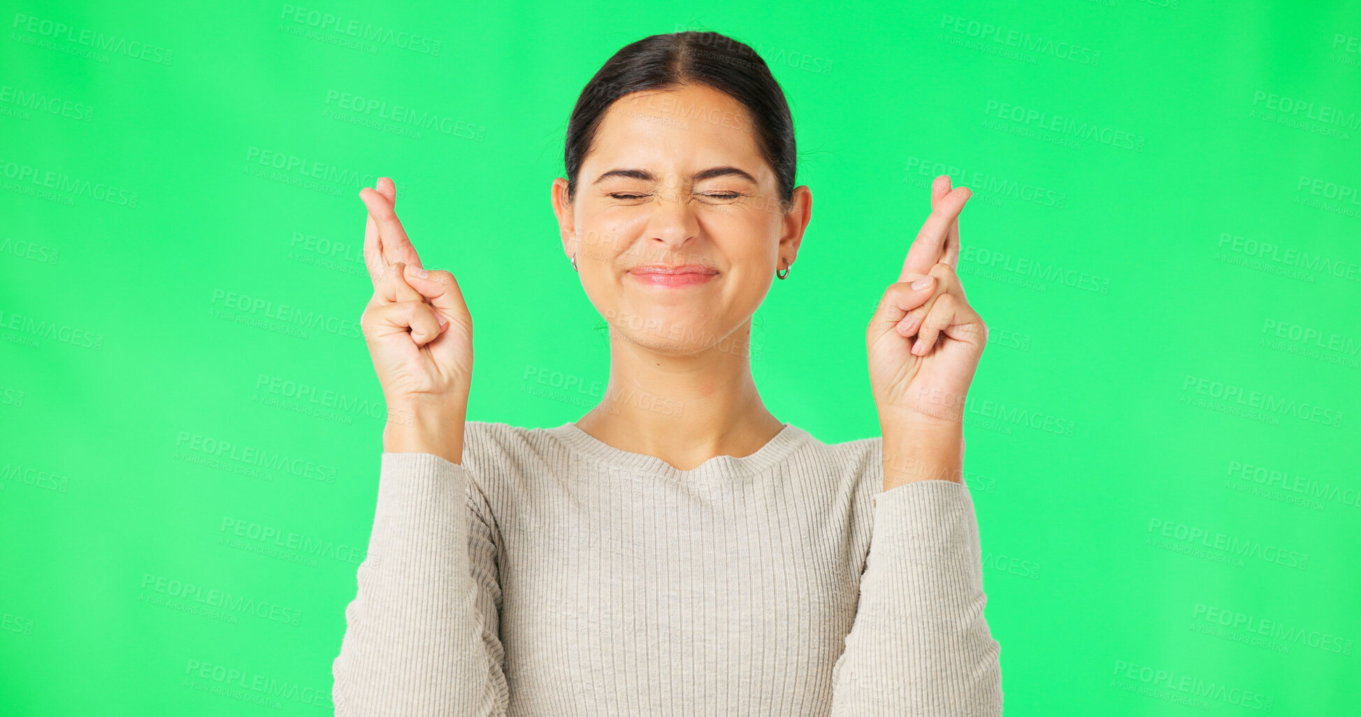 Buy stock photo Wish, face and woman with fingers crossed by green screen, studio portrait and good luck. Model, excited and hope to win in competition, optimism and giveaway prize with emoji sign, hands and smile