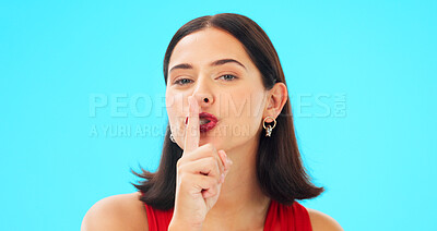 Buy stock photo Beauty, secret and woman whisper in portrait on blue background in studio for privacy, news or emoji. Model, face and finger on lips for silence, shush and quiet announcement or confidential gossip