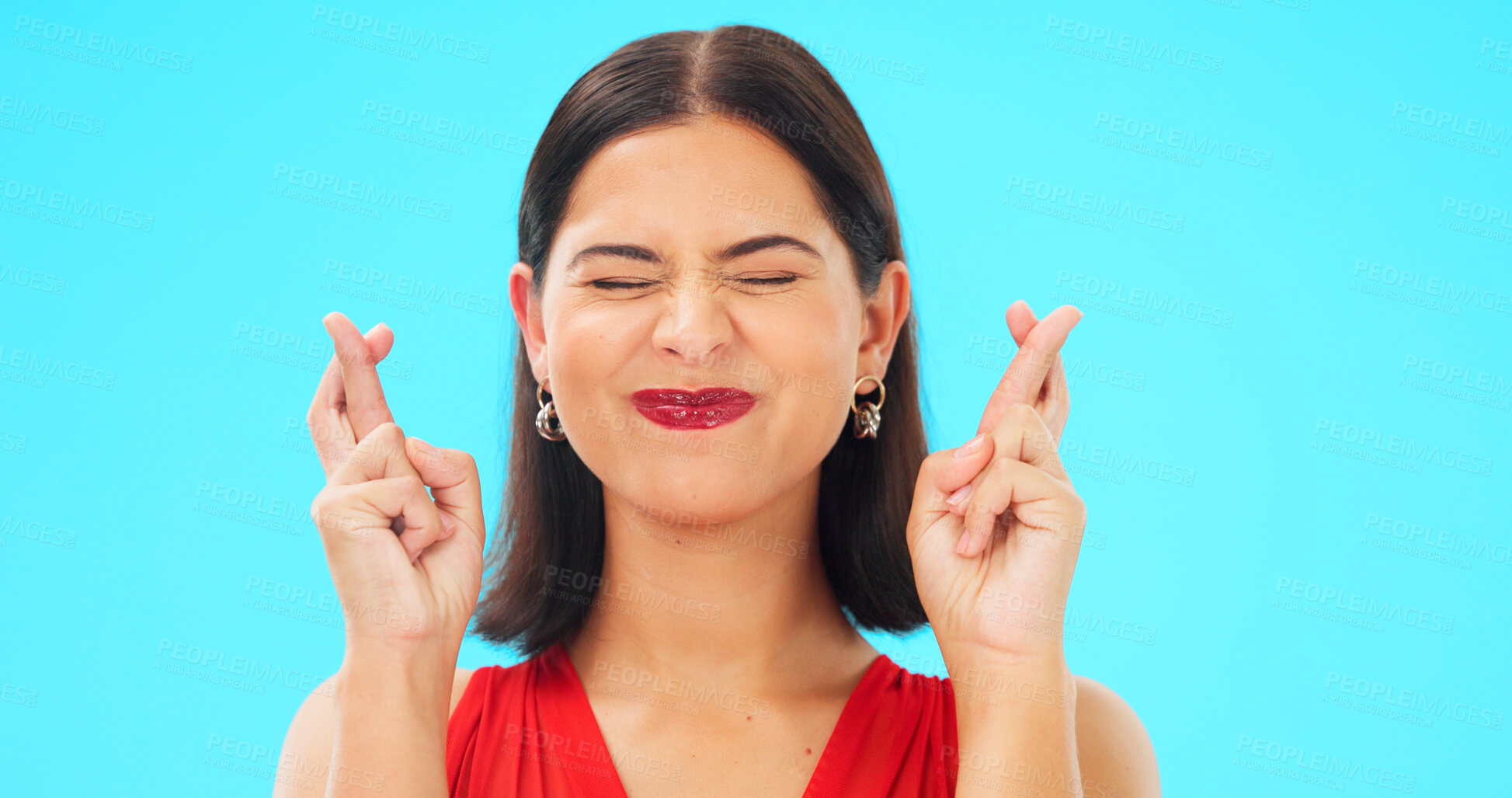 Buy stock photo Woman, cross fingers and hope in studio with eyes closed, good luck emoji or thinking by blue background. Girl, sign language or wish gesture for valentines day date, competition or ideas for prize