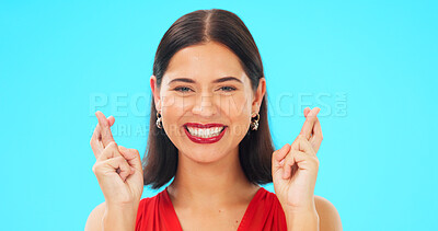 Buy stock photo Happy, woman and portrait with fingers crossed in studio wish for good luck, feedback and giveaway winner on blue background. Face of model hope for winning prize, optimism and smile with hand emoji 
