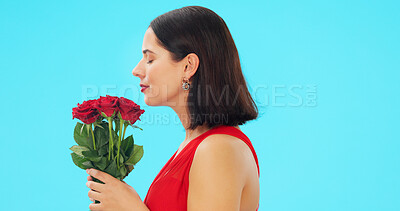 Buy stock photo Woman, smell roses and studio profile with valentines day gift for love, romance and kindness by blue background. Girl, floral bouquet and happy for present, beauty and date with plants with smile