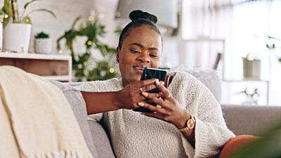 Black woman, phone and texting on a sofa with social media, app or online message in her home. Internet, meme and female relax in living room while reading, browsing and enjoy streaming subscription