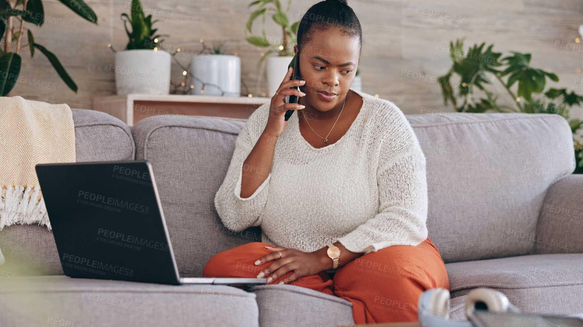 Buy stock photo Laptop, phone call and a concerned black woman on a sofa in the living room of her home for problem solving. Computer, communication and worry with a person talking on her mobile for networking