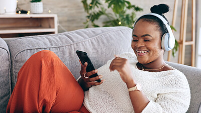 Dance, smartphone and black woman with headphones, audio streaming and stress relief on couch. Music, African American female and lady with headset, cellphone and dancing in lounge, sounds and smile