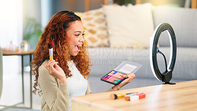 Beauty influencer filming a makeup tutorial at home. Young female blogger live streaming a broadcast online with ring light for a vlog channel. Recording a fun podcast for followers on social media