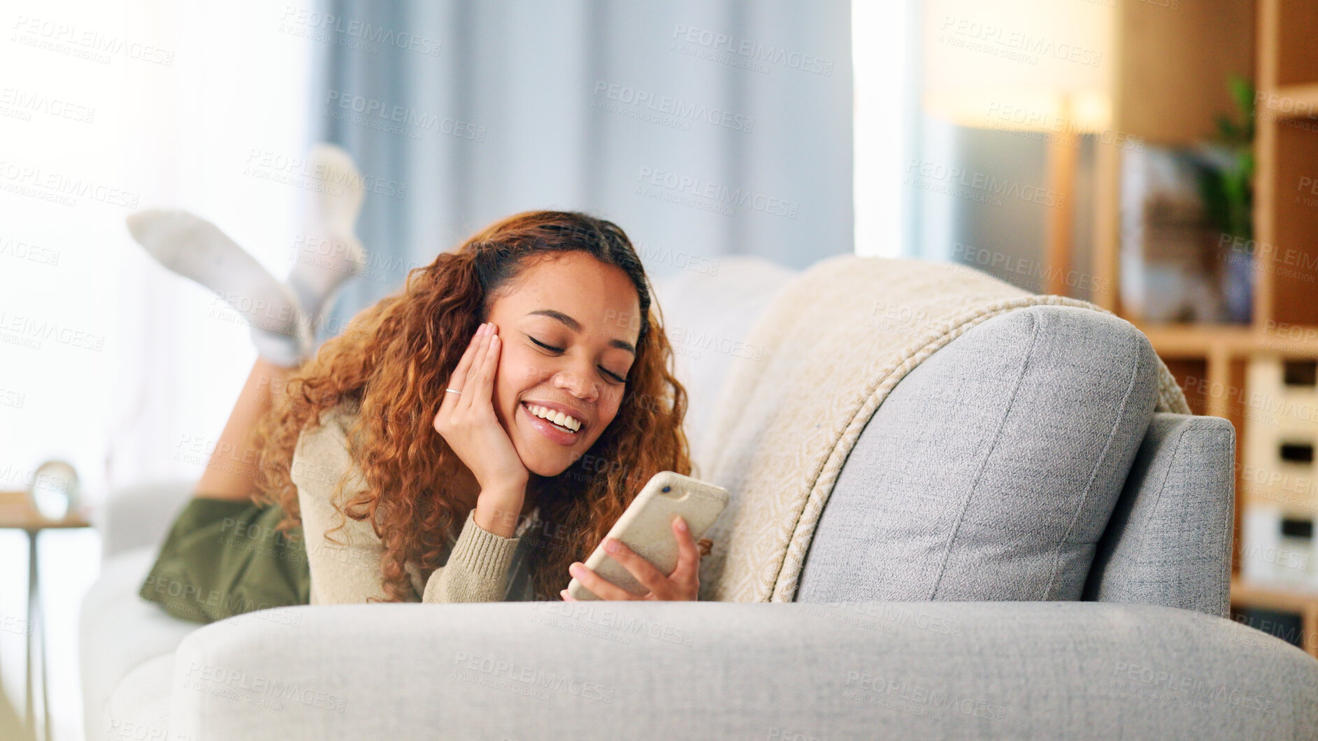 Buy stock photo Woman, smile and laughing on a phone for communication, a meme or social media at home. Happy, girl and reading a chat, online conversation or on a mobile app to relax on the living room sofa