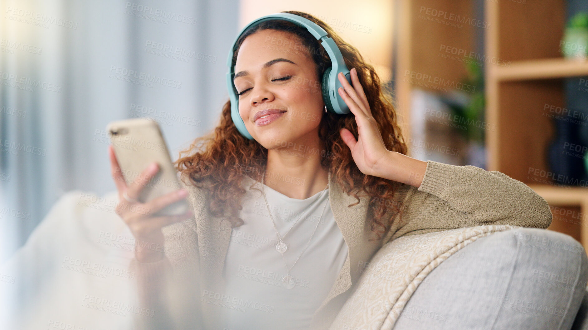 Buy stock photo Woman, headphones and music on couch, phone or thinking with smile, listen and relax in home. Girl, smartphone and happy for audio streaming subscription, app and radio with peace on living room sofa